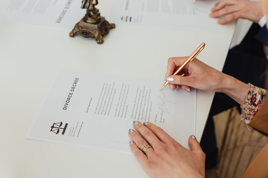 Couple signant des documents officiels dans une étude notariale lors d'une procédure de divorce.