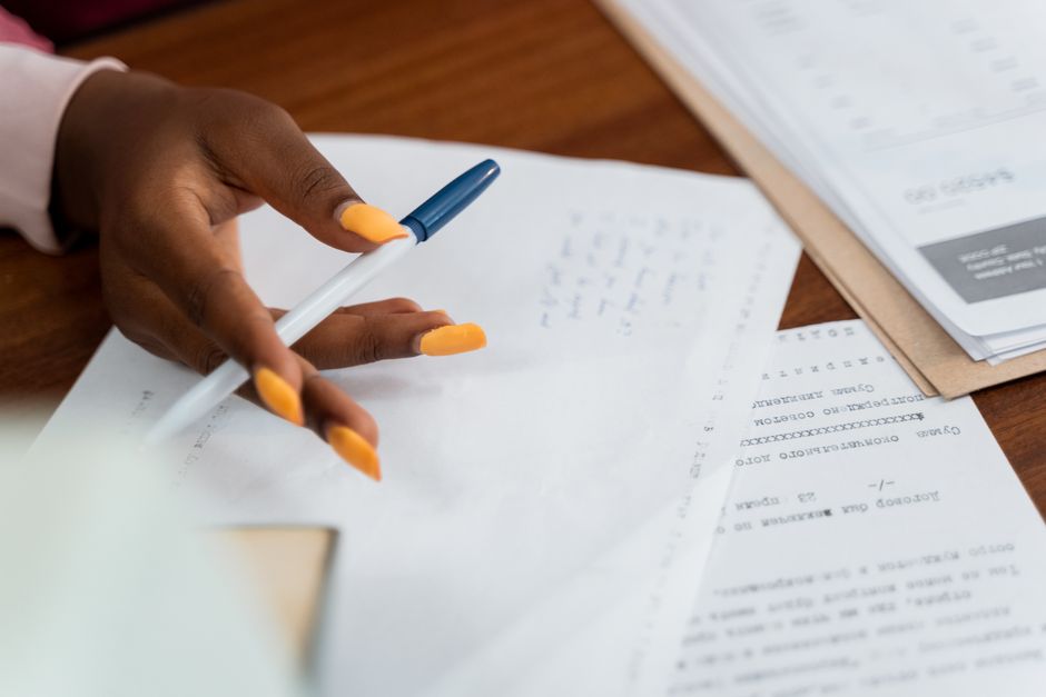 Personne rédigeant un testament à la main sur un bureau en bois avec un stylo plume